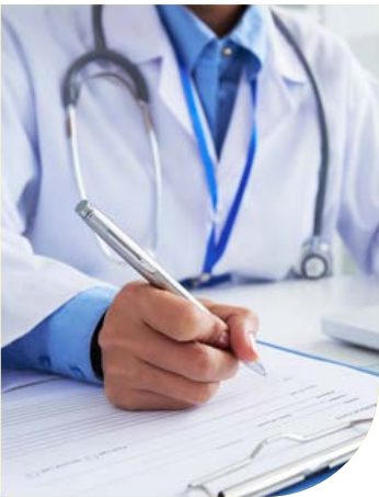 Medico in camice bianco con stetoscopio che compila una cartella clinica alla scrivania