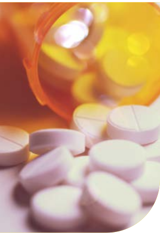 Flacone di medicinali rovesciato con numerose compresse bianche sparse su un piano, in una luce calda arancione e ambrata